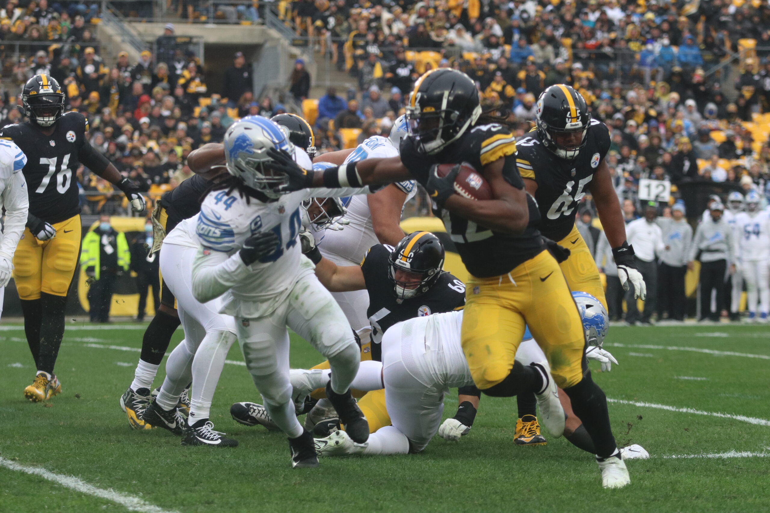 Steelers Running Back Najee Harris(#22) stiff arming Detroit Lion defender Jalen Reeves-Maybin (#44) as he looks for more running room ( Photo Credit: Vince Butts-UMT Sports) 