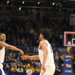 Pitt’s Gregg Elliott III and Nate Santos celebrate a last-second shot to end the 1st half